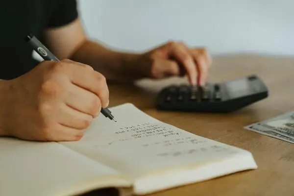 pessoa fazendo conta em calculadora