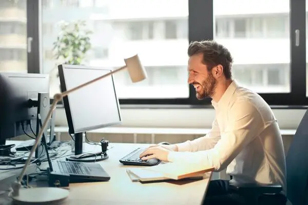 homem sorrindo e mexendo no computador